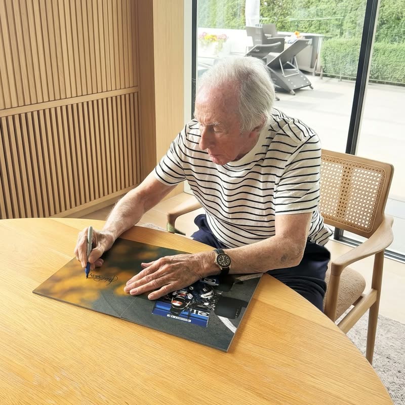 Sir Jackie Stewart signing a Framebook print
