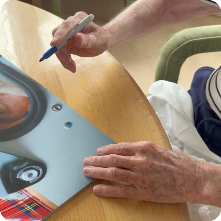 Sir Jackie Stewart signing a Framebook print